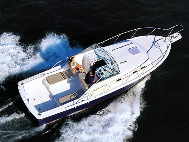 Slide: The Image of 2000 Mainship Pilot 30 boat interior with seating and storage, docked at marina. - 15