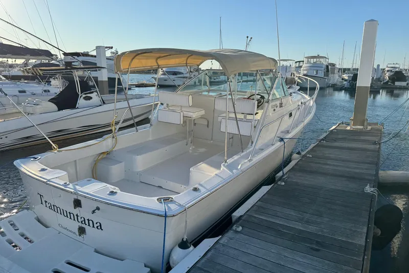 Slide: The Image of 2000 Mainship Pilot 30 boat helm with steering wheel and control panel, docked at marina. - 17