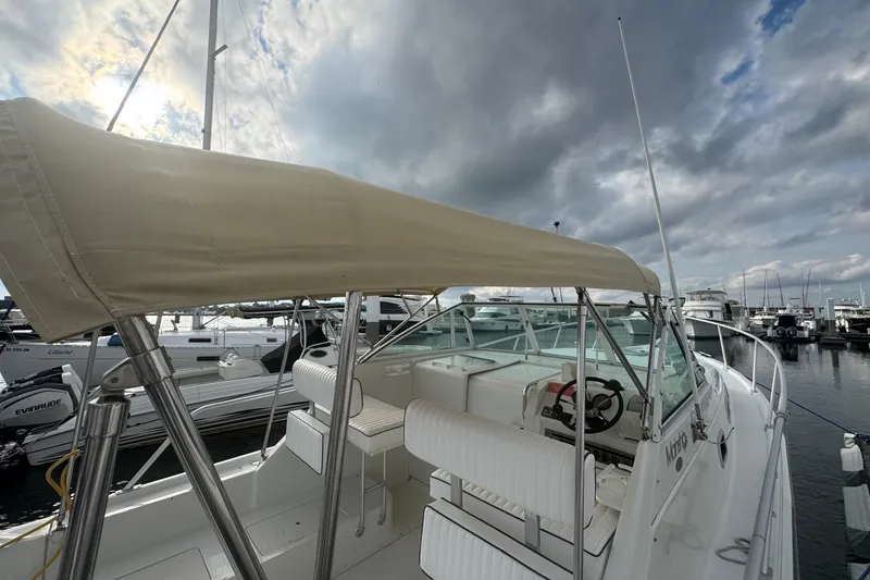 Slide: The Image of 2000 Mainship Pilot 30 boat docked, featuring a covered helm and marina backdrop. - 19