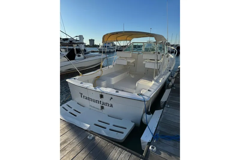 Slide: The Image of 2000 Mainship Pilot 30 boat docked at marina with beige canopy. - 2