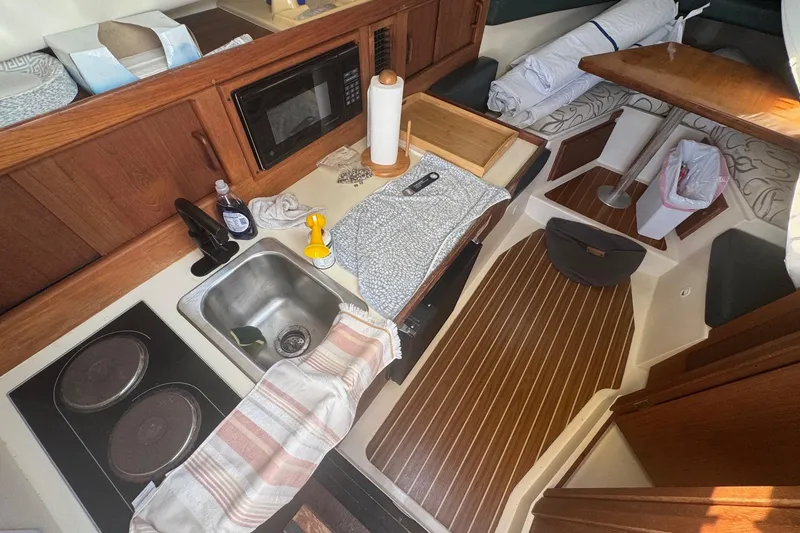 Slide: The Image of Interior of 2000 Mainship Pilot 30 boat with kitchen and seating area. - 20