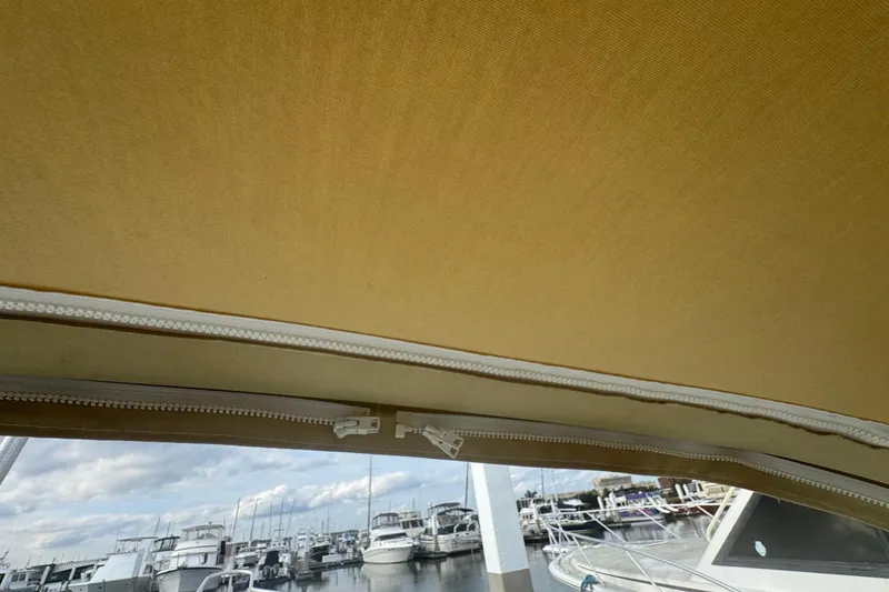 Slide: The Image of 2000 Mainship Pilot 30 boat canopy with marina view in background. - 24
