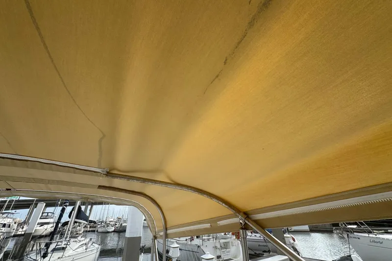 Slide: The Image of Yellow canopy of a 2000 Mainship Pilot 30 boat at a marina. - 25