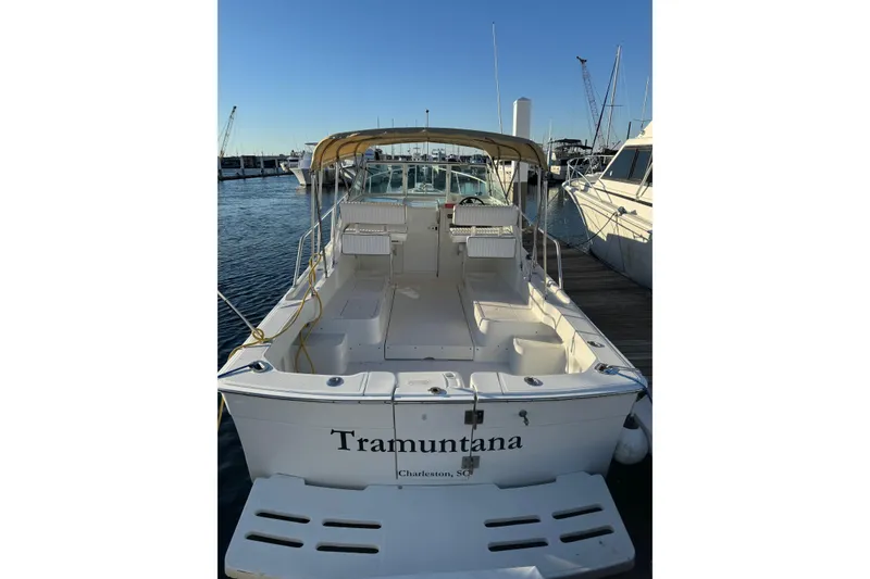 Slide: The Image of 2000 Mainship Pilot 30 docked at marina under cloudy sky. - 3