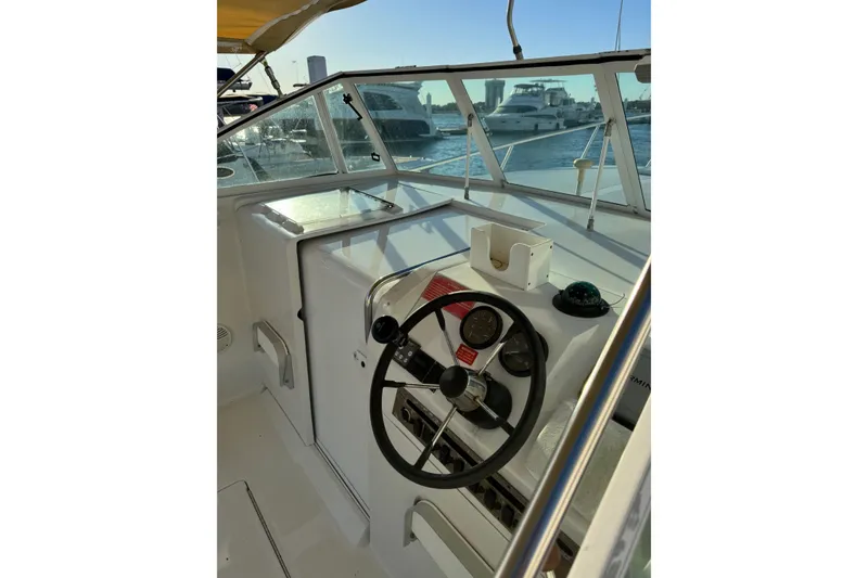 Slide: The Image of 2000 Mainship Pilot 30 boat docked at marina with other vessels in background. - 6