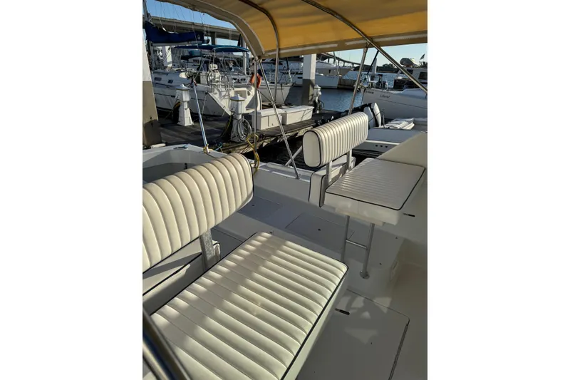 Slide: The Image of 2000 Mainship Pilot 30 boat docked at marina, featuring a beige canopy and spacious deck. - 7