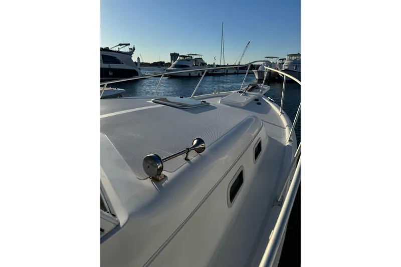 Slide: The Image of 2000 Mainship Pilot 30 boat docked, featuring spacious seating and clean deck design. - 8