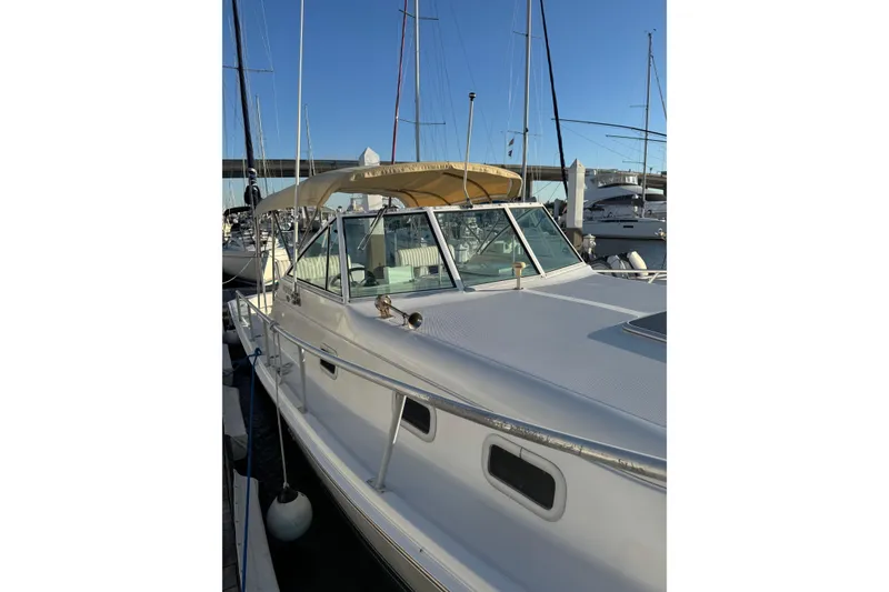 Slide: The Image of 2000 Mainship Pilot 30 docked at marina under cloudy skies. - 9