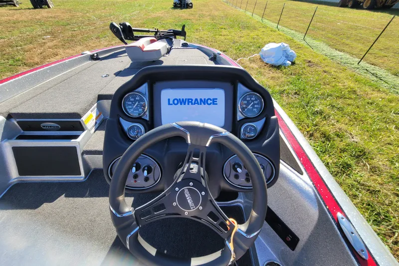 Slide: The Image of 2024 Triton 179 TrX boat dashboard with Lowrance display and steering wheel. - 12