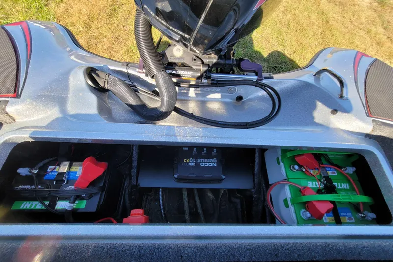 Slide: The Image of 2024 Triton 179 TrX boat battery compartment with NOCO Genius charger and Interstate batteries. - 16