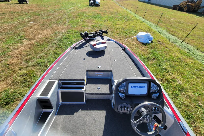 Slide: The Image of 2024 Triton 179 TrX boat with Lowrance electronics, parked on grassy field. - 7
