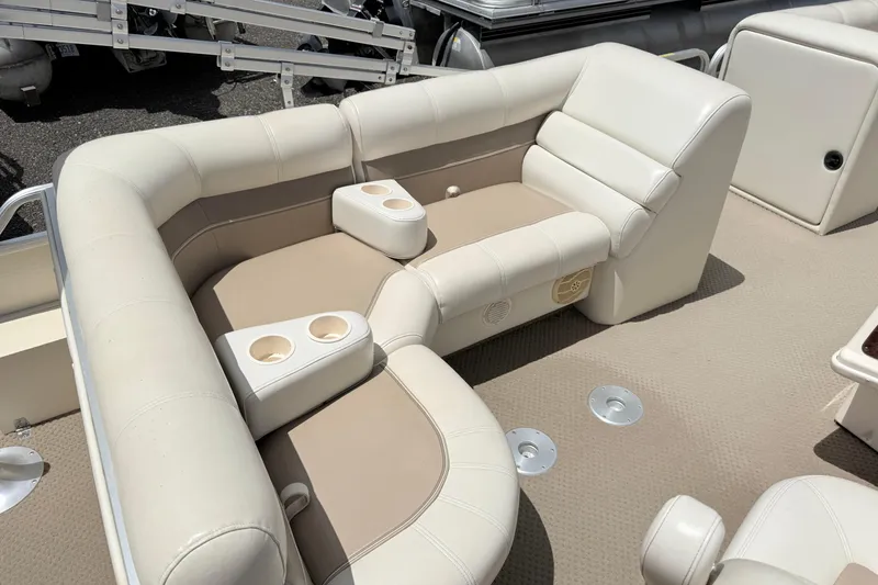 Slide: The Image of 2005 Aqua Patio 240 boat interior with beige seating and cup holders. - 11