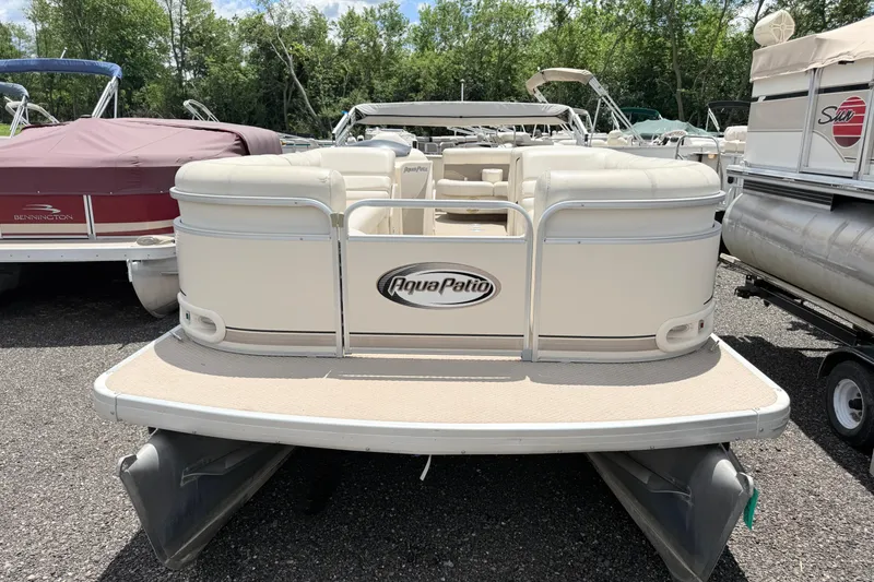 Slide: The Image of 2005 Aqua Patio 240 pontoon boat, beige exterior, parked among other boats. - 3