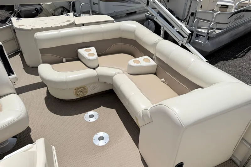 Slide: The Image of Luxurious seating on a 2005 Aqua Patio 240 boat, featuring beige and cream upholstery. - 7