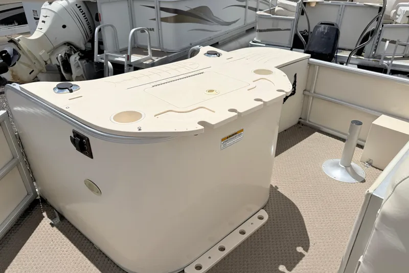 Slide: The Image of 2005 Aqua Patio 240 boat interior with storage compartment and Johnson outboard motor. - 10