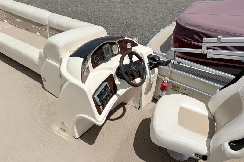 Slide: The Image of 2005 Aqua Patio 240 boat interior with steering wheel and seating. - 8