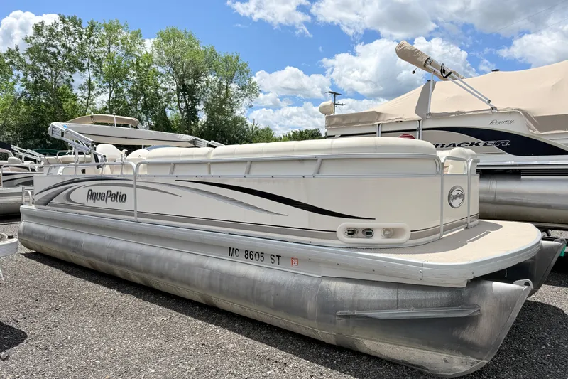 The Image of 2005 Aqua Patio 240 pontoon boat parked on gravel under a blue sky. - 0