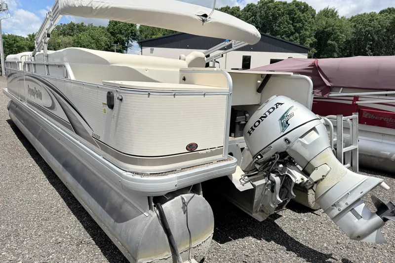 Slide: The Image of 2005 Aqua Patio 240 pontoon boat with Honda outboard motor, parked outdoors. - 2