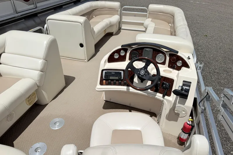 Slide: The Image of Interior of a 2005 Aqua Patio 240 boat with beige seating and control panel. - 12