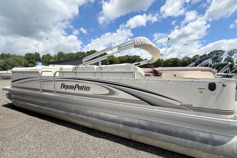 Slide: The Image of 2005 Aqua Patio 240 pontoon boat under a partly cloudy sky. - 1