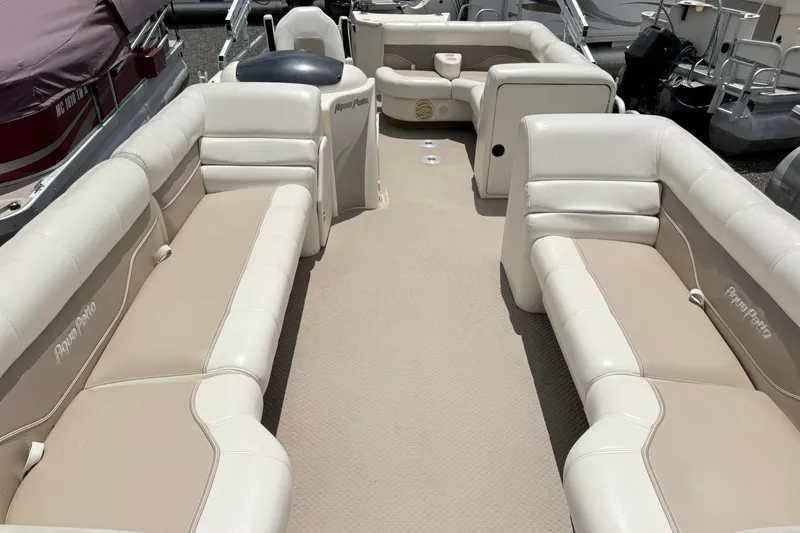 Slide: The Image of Interior view of a 2005 Aqua Patio 240 boat with beige seating. - 4