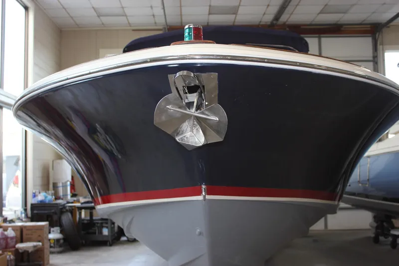 Slide: The Image of 2011 Chris-Craft Corsair 28 boat with navy hull and canopy in a marina setting. - 3