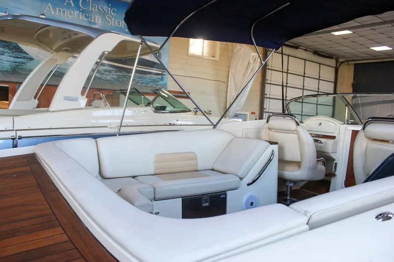 Slide: The Image of 2011 Chris-Craft Corsair 28 boat interior with teak flooring and white cushioned seating. - 48