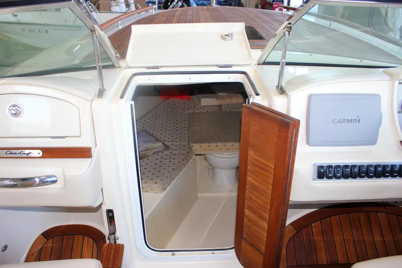 Slide: The Image of 2011 Chris-Craft Corsair 28 boat interior with white seating and wooden deck. - 54