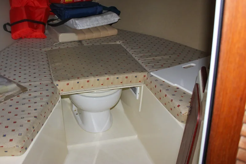 Slide: The Image of 2011 Chris-Craft Corsair 28 cabin interior with toilet and cushioned seating. - 61