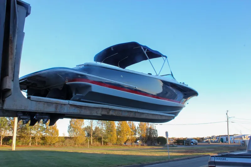 Slide: The Image of 2011 Chris-Craft Corsair 28 boat being transported on a trailer under a clear blue sky. - 66