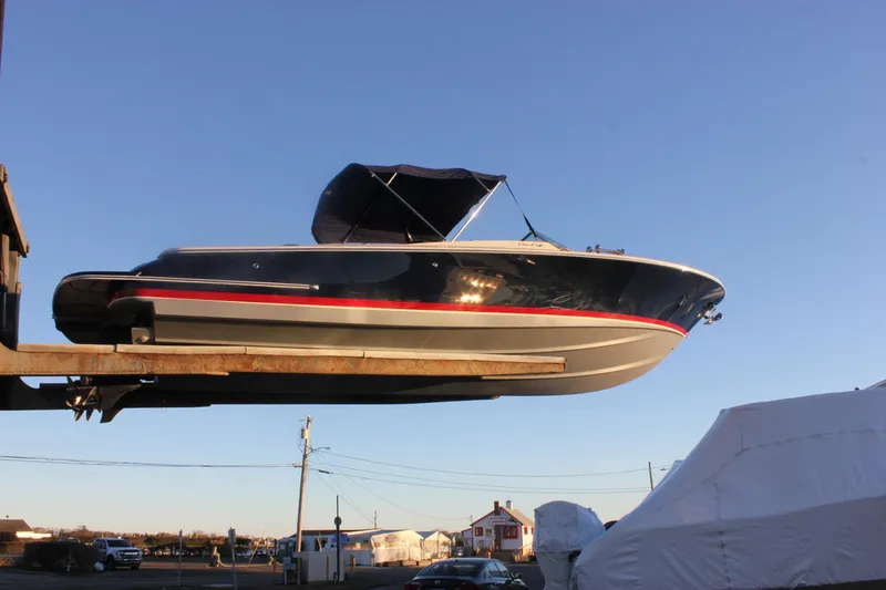 Slide: The Image of 2011 Chris-Craft Corsair 28 boat elevated on a lift against a clear blue sky. - 67
