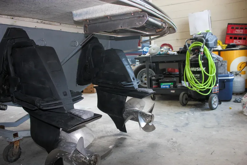 Slide: The Image of 2011 Chris-Craft Corsair 28 boat in a garage, showcasing sleek design and navy hull. - 8