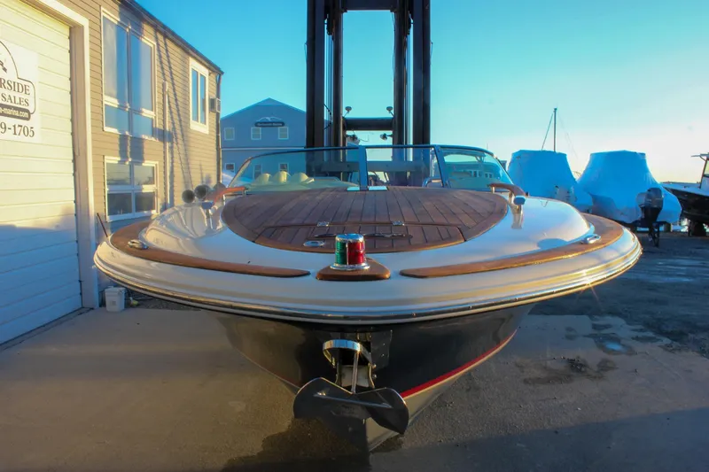 Slide: The Image of 2011 Chris-Craft Corsair 28 boat with wooden deck, docked near a marina building. - 81