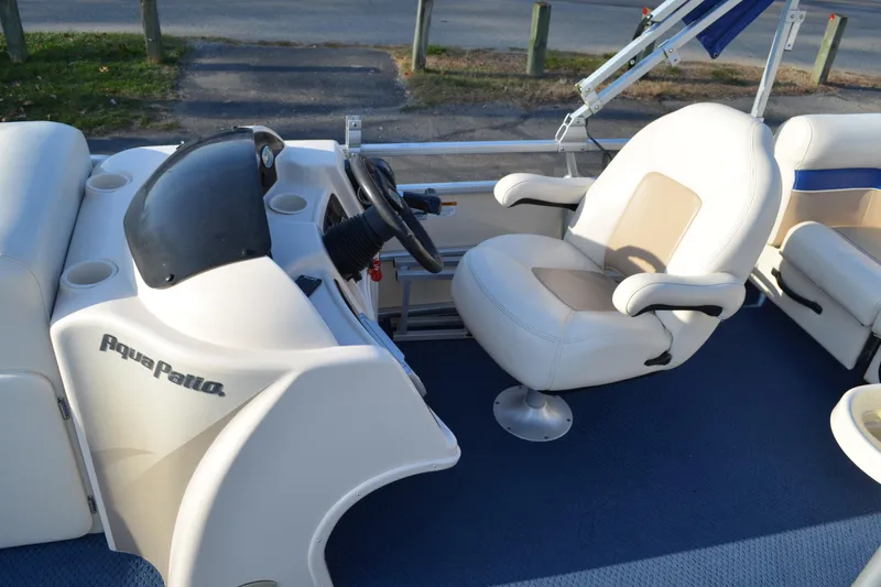 Slide: The Image of 2004 AquaPatio 22 boat interior with steering wheel and comfortable seating. - 14