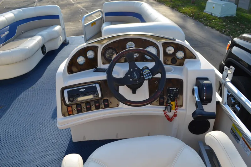 Slide: The Image of 2004 AquaPatio 22 boat dashboard with steering wheel and control panel. - 17