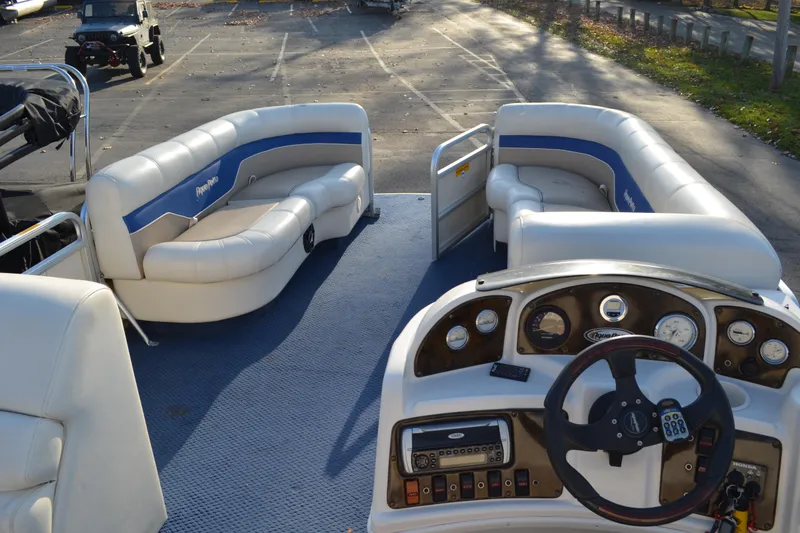Slide: The Image of 2004 AquaPatio 22 pontoon boat interior with blue carpet and white seating. - 18
