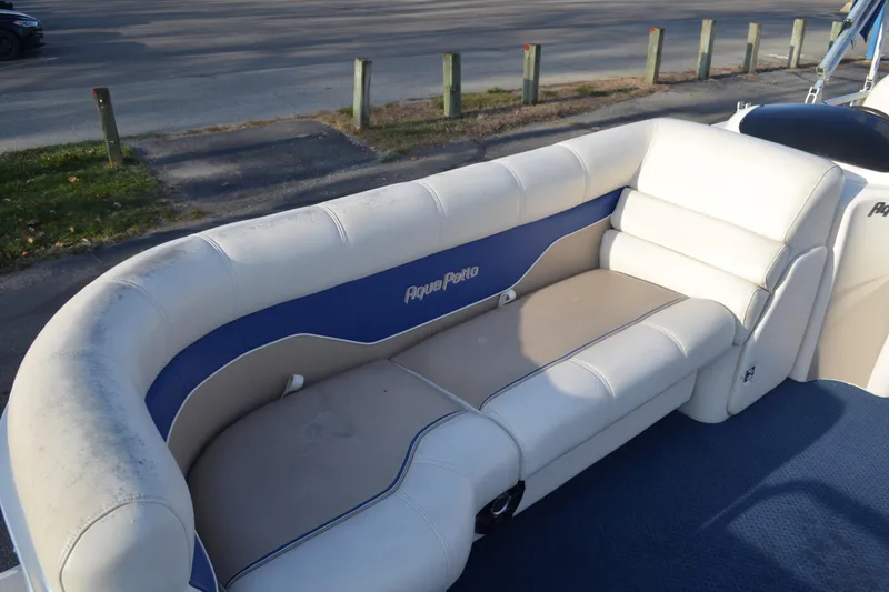 Slide: The Image of 2004 AquaPatio 22 boat interior with white and blue cushioned seating. - 7
