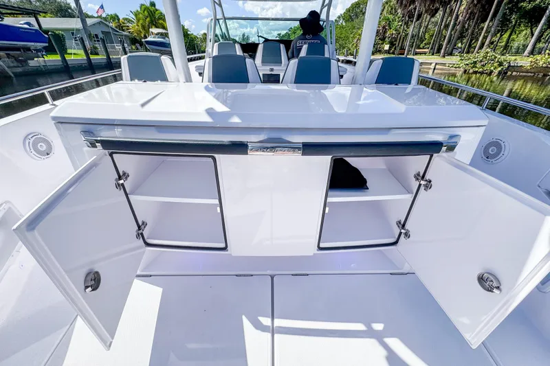 Slide: The Image of 2024 Axopar 37 Sun Top boat with open storage compartments on deck. - 13