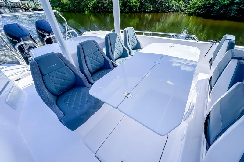 Slide: The Image of 2024 Axopar 37 Sun Top boat interior with stylish seating and table, featuring dual Mercury engines. - 17
