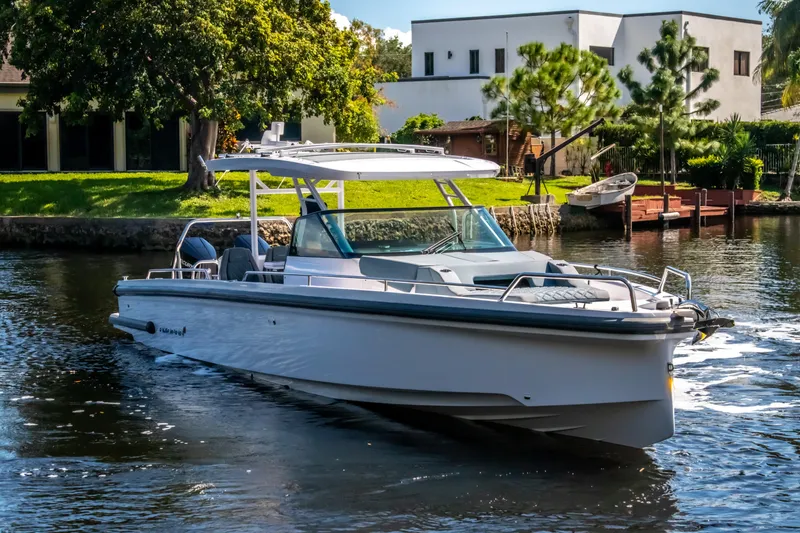 Slide: The Image of 2024 Axopar 37 Sun Top boat cruising on a scenic waterway. - 5