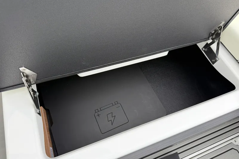 Slide: The Image of Open storage compartment in 2026 Moomba Max boat, featuring battery icon. - 18