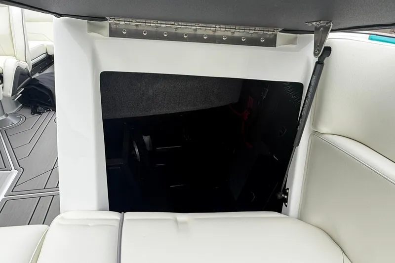 Slide: The Image of 2026 Moomba Max boat interior storage compartment with white seating and gray flooring. - 29