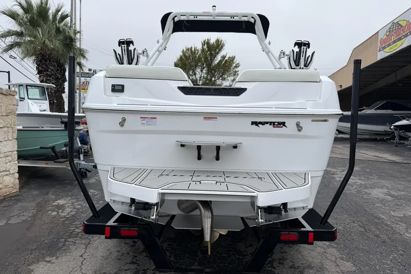 Slide: The Image of 2026 Moomba Max boat rear view, featuring Raptor engine, parked outdoors. - 6