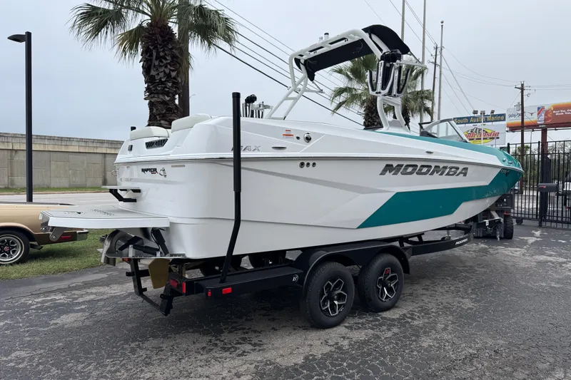 Slide: The Image of 2026 Moomba Max boat on trailer, white and teal design, parked near palm trees. - 8