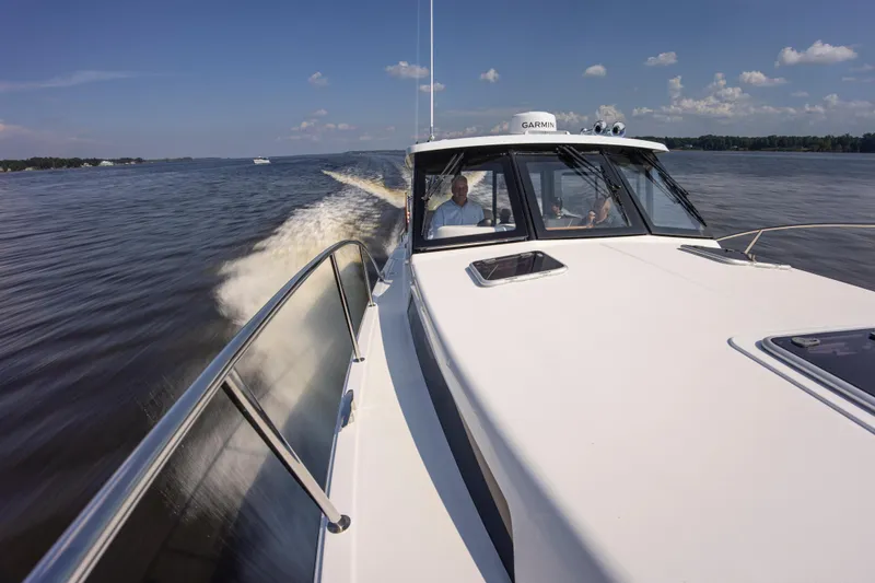 Slide: The Image of 2025 MJM 42 boat cruising on a sunny day with passengers onboard. - 11