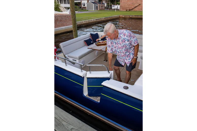 Slide: The Image of Man on MJM 42 boat, 2025 model, docked by waterfront. - 14