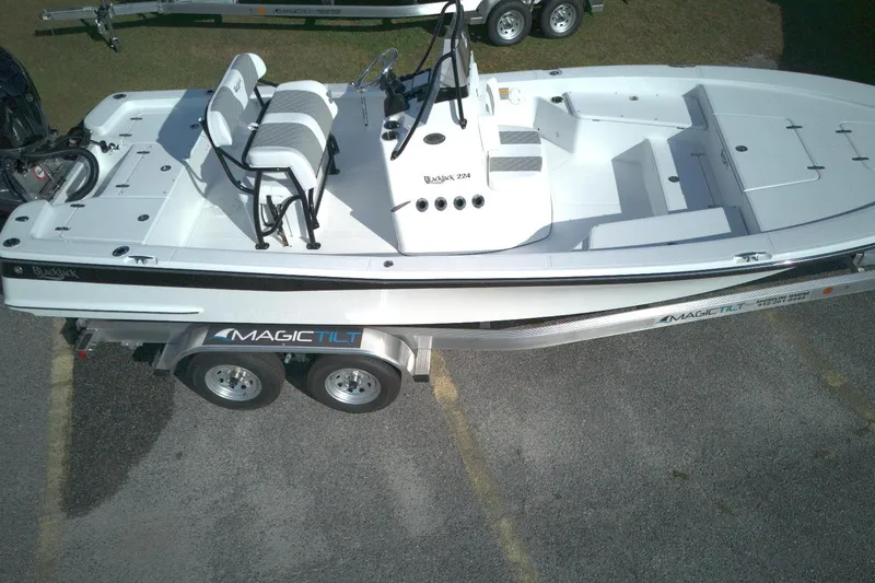 Slide: The Image of 2026 BlackJack 224 boat on Magic Tilt trailer, viewed from above, parked on pavement. - 10