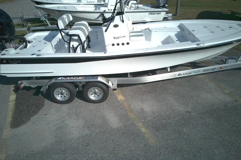 Slide: The Image of 2026 BlackJack 224 boat on Magic Tilt trailer, parked in a lot. - 11