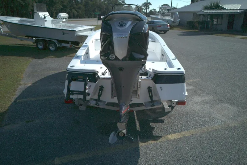 Slide: The Image of 2026 BlackJack 224 boat with outboard motor, parked on a sunny day. - 13