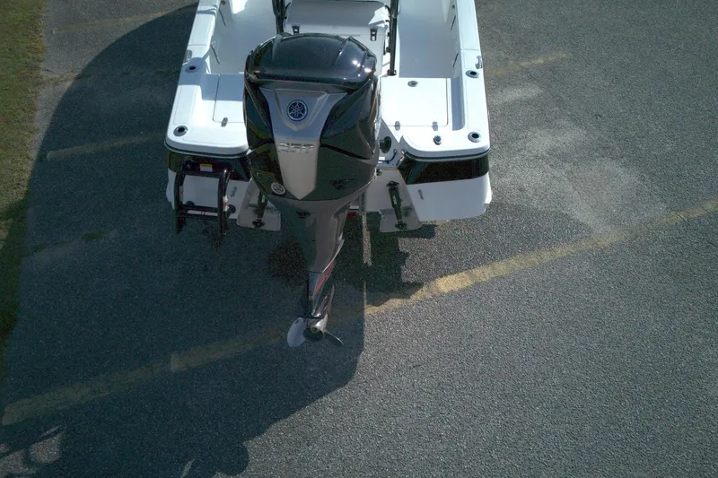 Slide: The Image of Rear view of 2026 BlackJack 224 boat with outboard motor on pavement. - 2